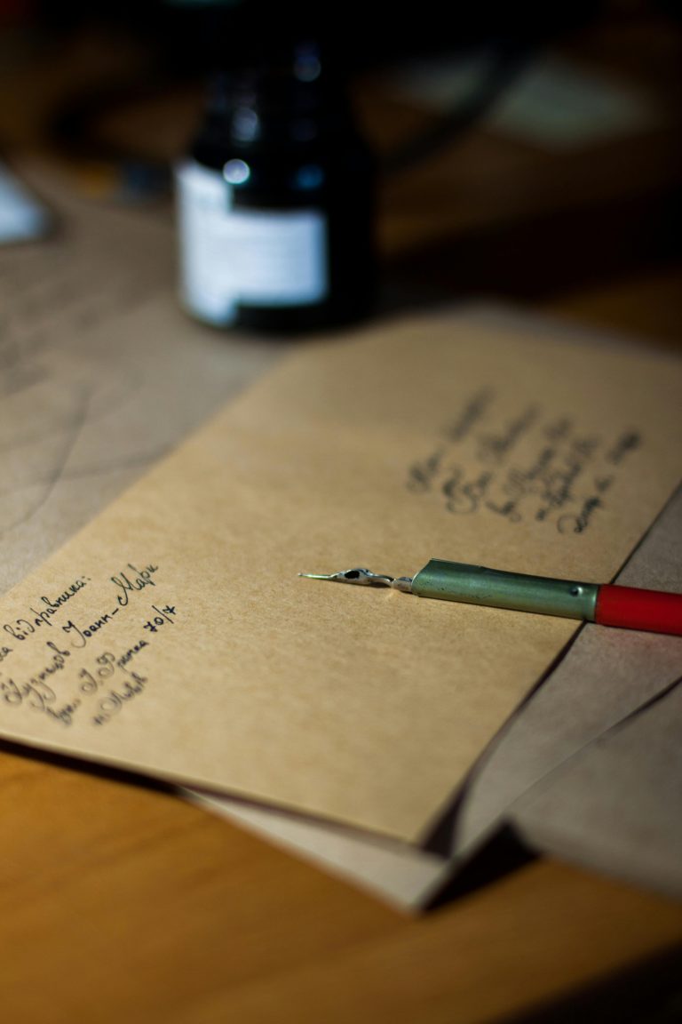 Close-up of vintage letters with a pen and ink, showcasing classic handwriting.